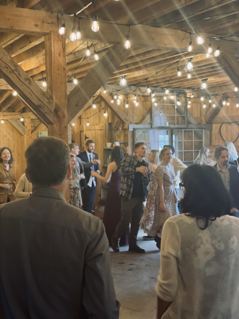 Wedding dancefloor with guests celebrating under warm string lights
