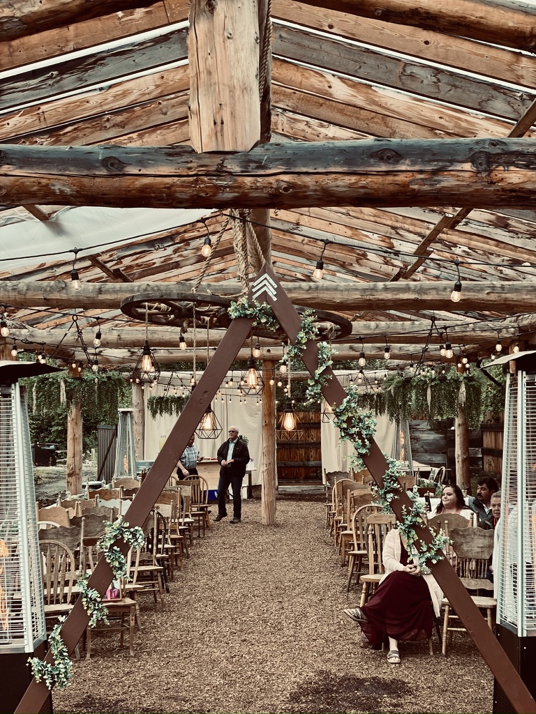 Event room viewed from the DJ setup with guests seated under chandeliers